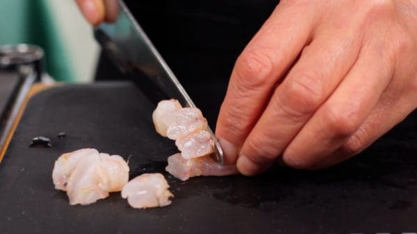 Then, for the topping of the shumai, cut up some of the shrimp into 18 pieces about the size of the tip of your little finger.
