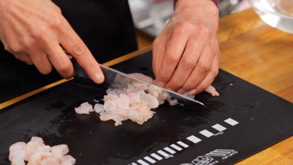 把剩下的虾肉切成薄片，然后用刀切碎。