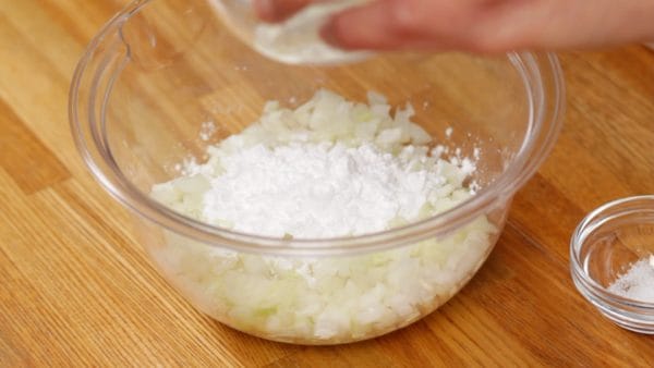 Let's make the meat filling. First, add the potato starch to the chopped onion in a bowl.