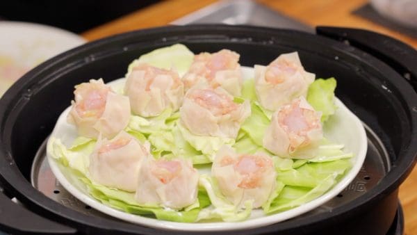 Arrange the shumai on the cabbage so that they do not stick to each other. You can also place the shumai or cabbage directly on parchment paper without using the plate.
