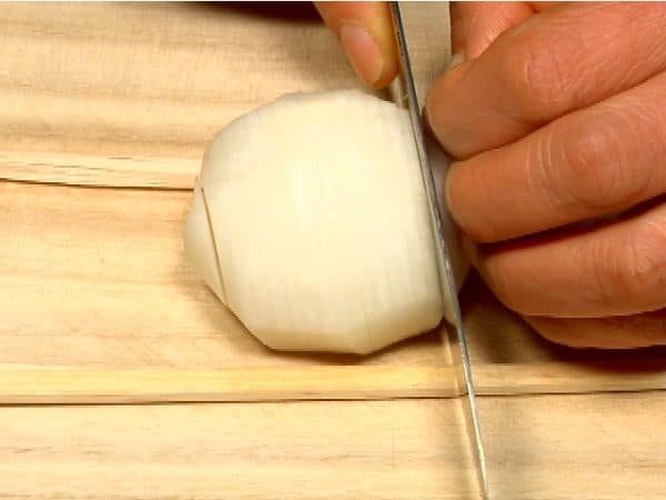 Place the turnip between 2 disposable chopsticks with the stem end facing down. Thinly slice the turnip. The chopsticks will help to keep the bottom from separating.