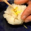 Formez le navet en fleur de chrysanthème et décorez avec le zeste de yuzu et le piment rouge.