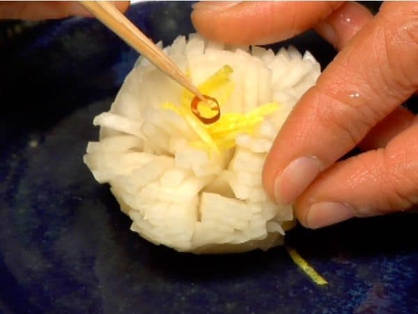 Shape the turnip into a Chrysanthemum flower and garnish with the yuzu peel and red chili pepper.