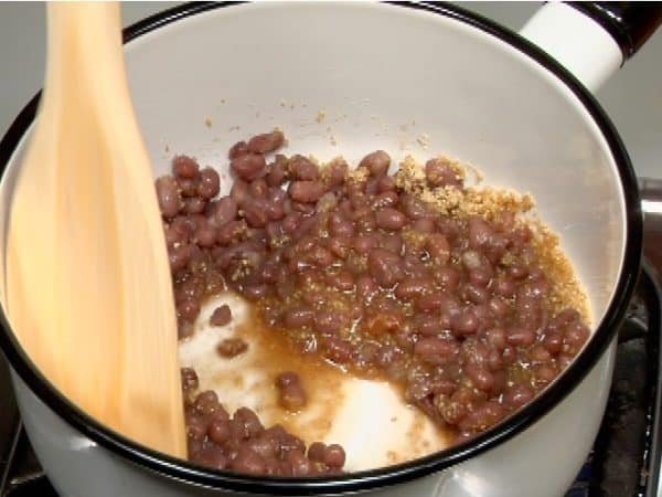 Reduce the liquid on medium heat while stirring the red bean mixture with a wooden paddle to avoid burning.