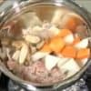 Quand la viande devient brune, ajoutez le konjac, le radis daikon, la carotte et la racine de bardane.