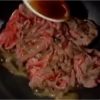 Sau đó, múc sốt sukiyaki lên thịt bò.
