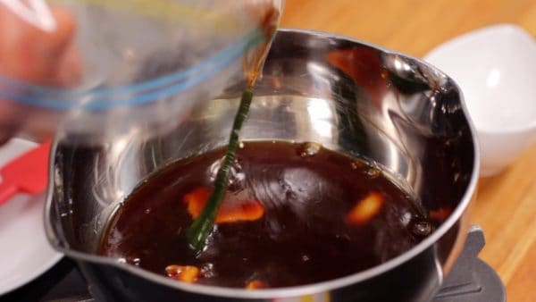 Während das Fleisch backt, bereiten wir die Soße für Char Siu vor. Gieß die übrig gebliebene Marinade in einen kleinen Topf und erhitze sie.
