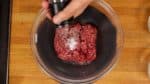 Add one-third teaspoonful of salt and pepper to the ground beef.