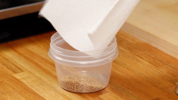 Place the sesame seeds into a food storage container.