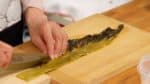 接下來，讓我們將醃製的芥末葉子切碎。將薄葉部分與中間厚部分分開。