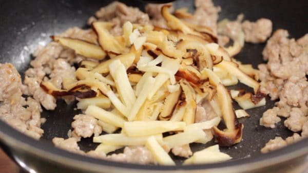 When it begins to smell good, add the bamboo shoot and rehydrated shiitake mushroom.