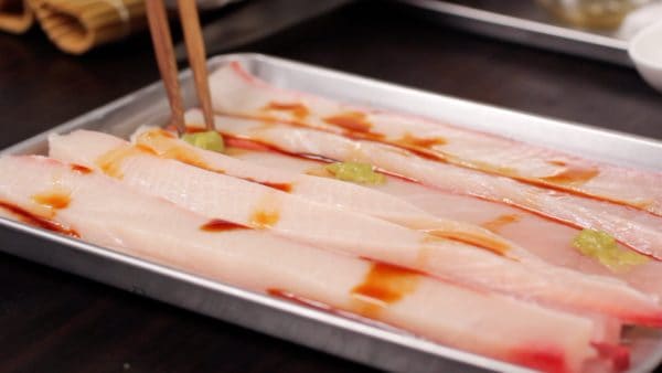 Transfer the yellowtail to a tray and add a little soy sauce. Add some wasabi to taste.