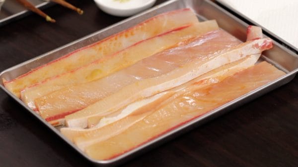 把调味料均匀地涂在黄尾鱼上。
