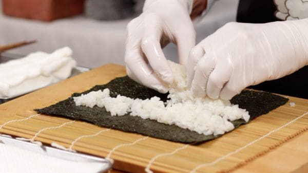 Take another portion of sushi rice and spread it out as well.