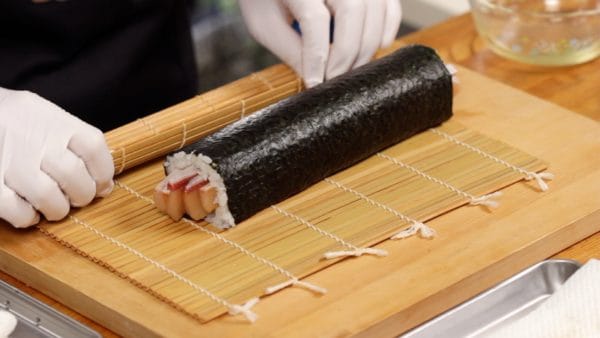Bỏ tấm tre dùng làm cơm cuộn (sushi) ra khỏi cơm cuộn Tekkamaki.
