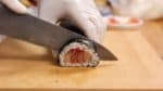 切割前，先用濕布擦拭刀片，輕輕潤濕。壽司卷通常被切成 8 片，但因為我們希望它是一口大小，所以我們將它切成稍薄的片。
