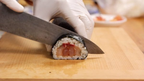 Before cutting, wipe the knife blade with a damp cloth to lightly moisten it. The sushi roll is often cut into 8 slices, but since we want it to be bite-sized, we'll cut it into slightly thinner pieces.