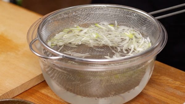 Soak the onion in ice water for about 15 minutes. Soaking in cold water will dissolve the pungent components in the water and soften the pungency.
