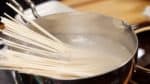Maintenant, préparez les Udon Hippari. Placez les nouilles udon sèches dans une généreuse quantité d'eau bouillante, en étalant les nouilles.