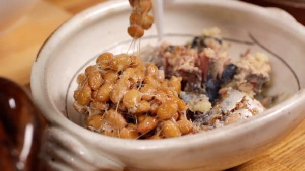 Next, add one pack of natto, fermented soybeans to the mackerel. You can also use finely chopped natto called "Hikiwari Natto" if you prefer.