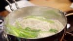 Ahora, el udon está casi listo. Añada sus verduras favoritas. Esta vez, utilizamos perejil japonés. Añadir las verduras después incrementa el valor nutricional. Remueva y apague el fuego. 