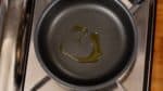 Now let's cook the salmon hamburg. Heat the olive oil in a pan on medium heat. Swirl the pan to coat it with the oil.