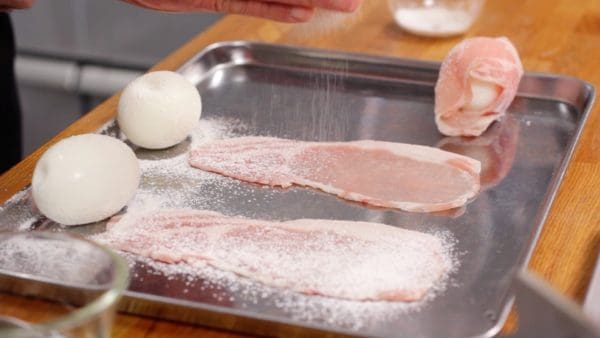 在煮熟的鸡蛋和猪里脊片上撒上任何一种小麦粉，这将有助于肉和鸡蛋牢固地粘在一起。
