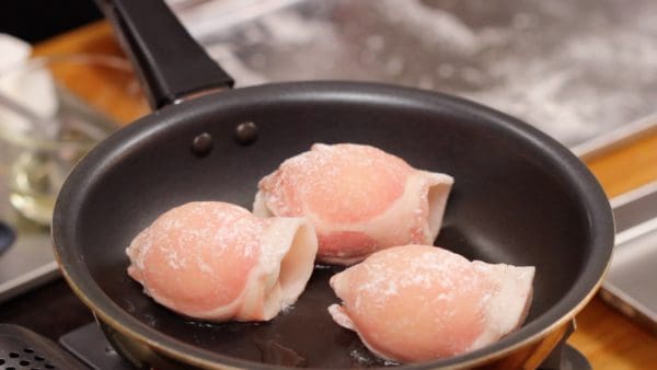 将裹肉的鸡蛋排入锅中，封住的一端朝下，防止肉片脱落。