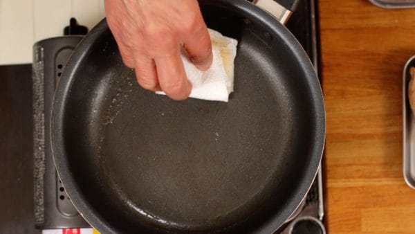用纸巾快速擦拭平底锅。