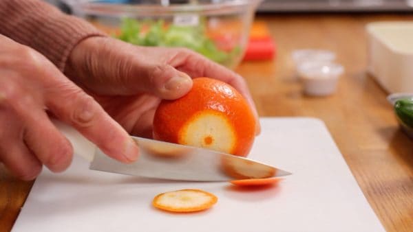 这是鹿儿岛县产的柑橘 (Tankan citrus)。将柑橘冲洗干净，从茎端和底部切下薄片。