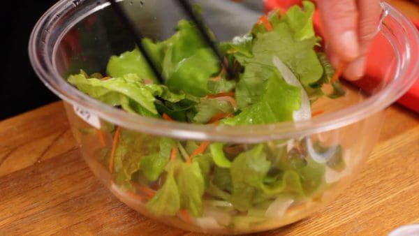 Ajoutez l'oignon nouveau et mélangez la salade depuis le fond. Une petite quantité d'oignon nouveau va rendre la salade meilleure.