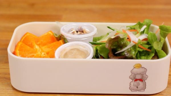 将沙拉装满便当盒。在小杯子里放上核桃作为配料和您最喜欢的调料，然后将它们放入便当盒中。
