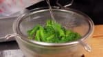 快速取出油菜花，倒入冷水使其冷卻。這樣可以幫助菜花不變色。