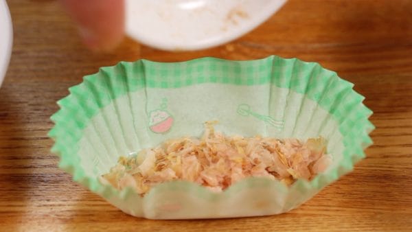 Cover the bottom of the bento cup liner with katsuobushi, bonito flakes.