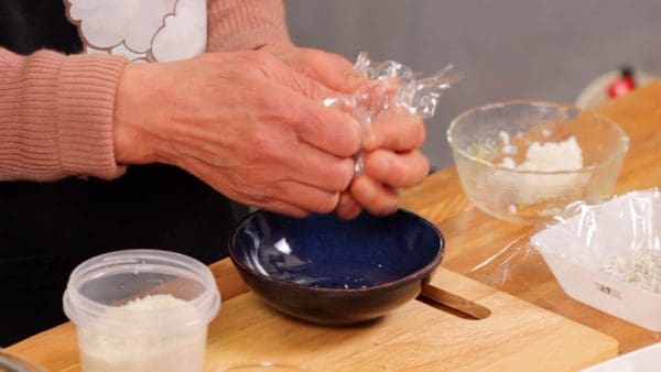 Espolvoree un poco de sal en el arroz y dé forma a otro onigiri de la misma manera.