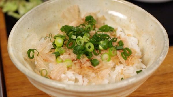 Spread the bonito flakes on top of another rice bowl. Add the chopped spring onion leaves.