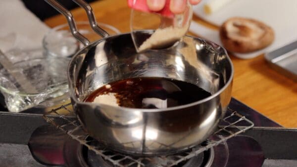 First, let's make the sukiyaki sauce. Combine the soy sauce, sake, mirin, and raw sugar in a small pot.