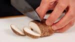 去除新鮮香菇的莖。將香菇的帽蓋切成 5 毫米（0.2 英寸）厚的薄片。
