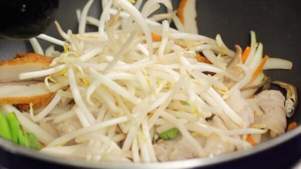 When the vegetables are almost cooked, add the moyashi bean sprouts and satsuma-age, fried fishcake and continue to stir-fry.