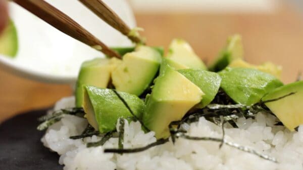 Place the 1.5 cm cubes of avocado on the rice. This is plenty of avocado, isn't it? It will be even more delicious when you pour the marinade on it.