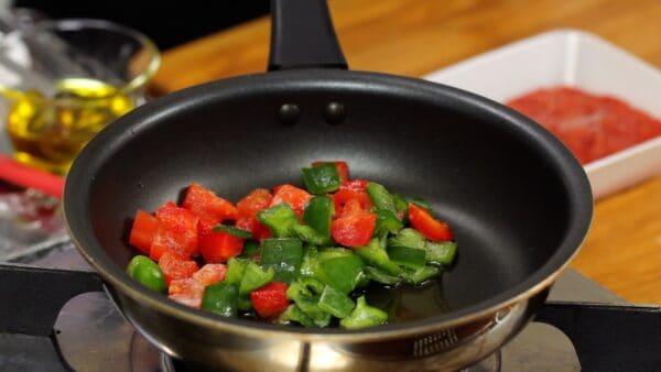 Add about a half tablespoon of olive oil and saute the green and red bell peppers stored in the freezer on high heat.