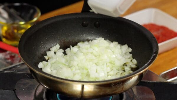 Next, add 1 tablespoon of olive oil. Add the chopped onion. This is plenty of onion, isn't it?