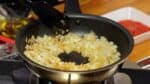 Lorsque l'oignon sur les bords de la casserole commence à dorer, retournez légèrement le centre pour voir à quel point il a bruni. Si la couleur est trop claire, aplatissez à nouveau l'oignon.