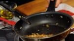 Ensuite, éteignez le feu et déplacez l'oignon de l'autre côté. Inclinez la casserole et ajoutez une demi-cuillère à soupe d'huile d'olive.