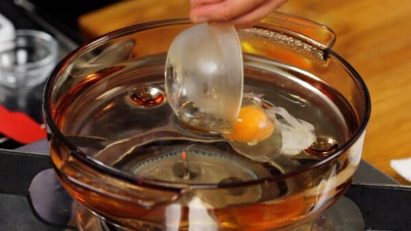 When it begins to simmer, gently place the eggs one at a time into boiling water.