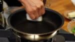 Veeg de pan schoon met een keukenpapiertje. Verhit de pan daarna weer. 