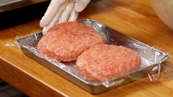 The patty will puff up while cooking, so if you dent it like this beforehand, it will be just the right shape.