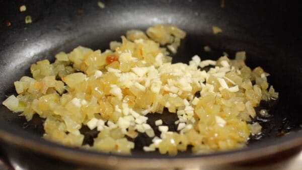 When the onion is warm, add the chopped garlic and mix quickly.