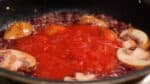 When the alcohol has completely evaporated, add the packaged, boiled tomatoes. We finely cut the whole tomatoes with kitchen scissors.