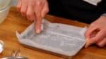 Besmeer eerst de bakvorm met zonnebloemolie om er voor te zorgen dat het bakpapier niet rondschuift. Het bakpapier moet stevig vast zitten aan de zijkanten van de bakvorm zodat de taart mooi bakt zonder onevenheden.